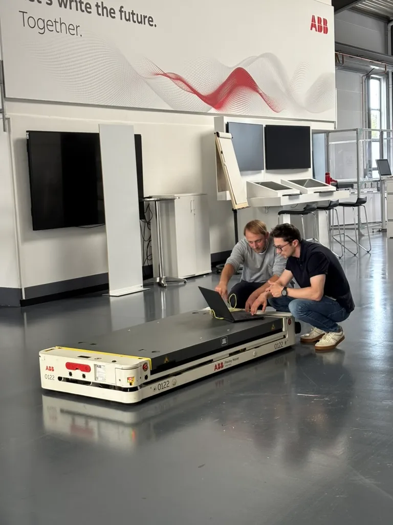 Zwei Personen bei der Konfiguration eines ABB-AMR am Laptop